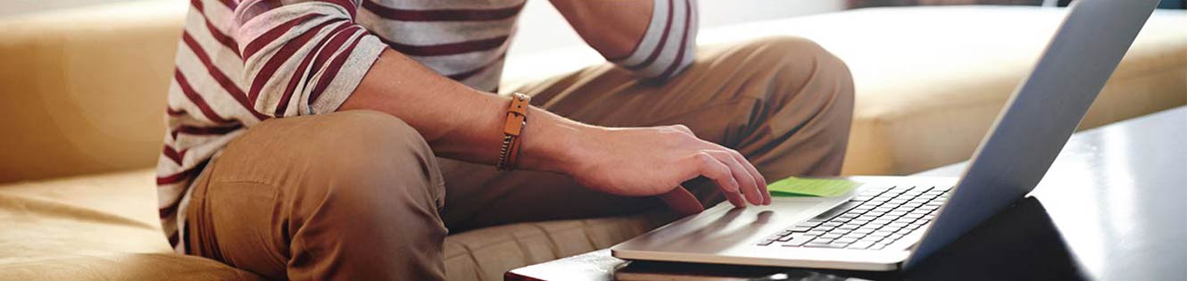 Person sitting in front of a laptop working.