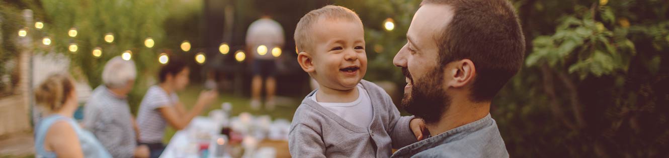 Father holding his child at outdoor diner.