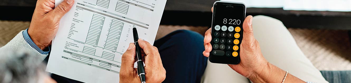 Couple reading over a financial statement while using a calculator.