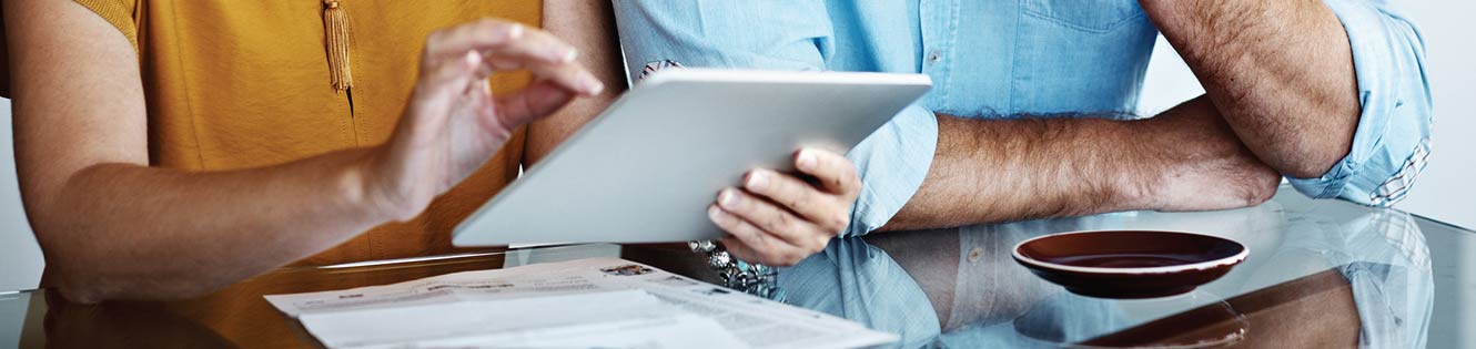 Couple using a tablet to look at their banking account.