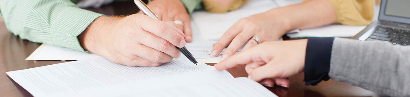 Multiple people examining a document.